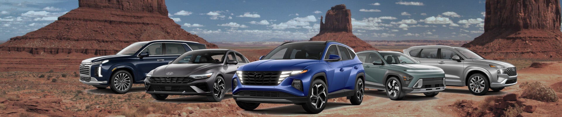 Front three-quarter view of Hyundai vehicle lineup in various colors against a red rock desert bac